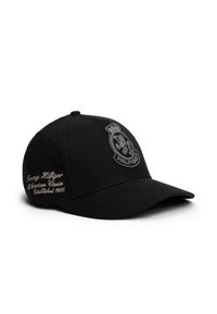 Gorra de béisbol negra de tela con visera curva. Presenta un logo bordado en el frente y el nombre de la marca en texto plateado en el lateral.