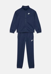 Jūras spēku sporta tērps, kas izgatavots no gludas auduma, ar ar rāvējslēdzēju aizveramu jaku un augstu apkakli, kā arī elastīgiem piedurkņu galiem, kopā ar saskaņotām biksēm. Balts logo.