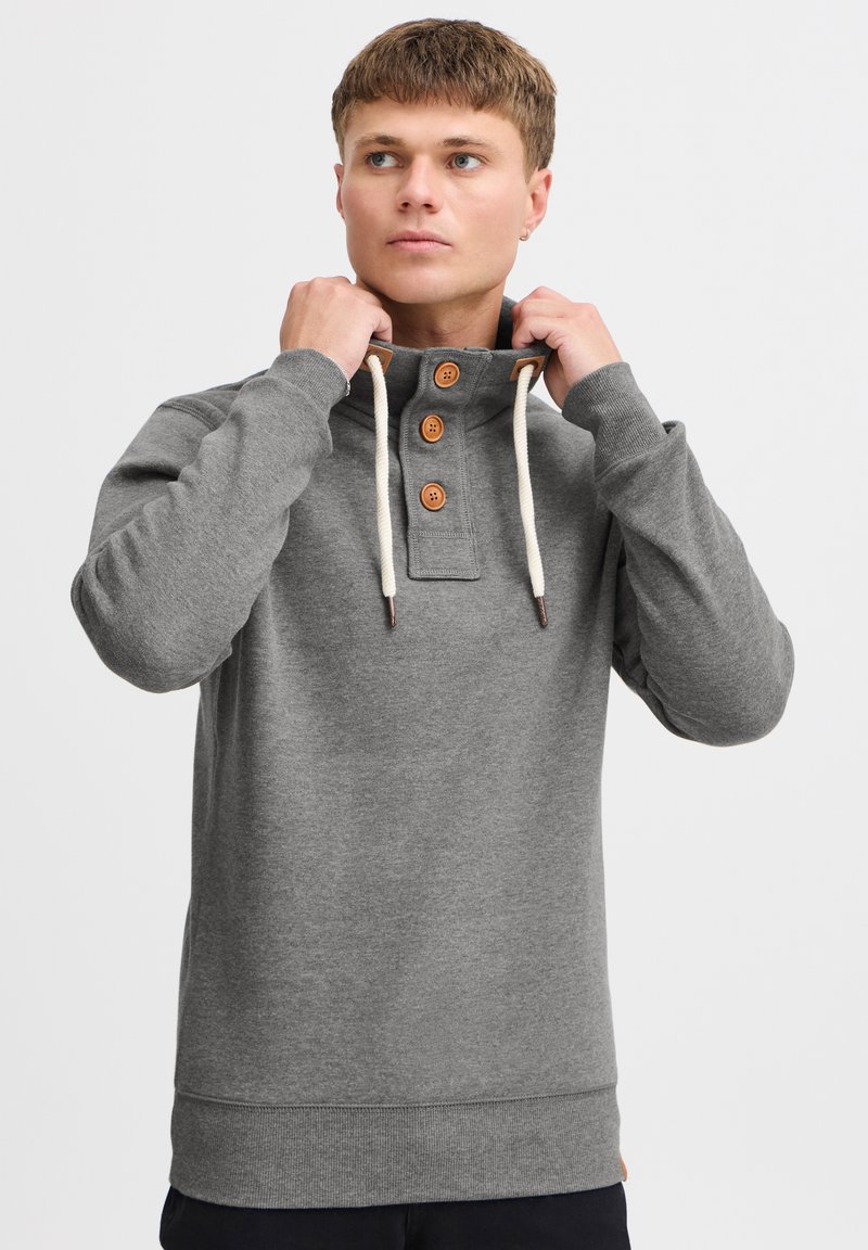 Gray pullover sweatshirt with a high collar, three wooden buttons, and white drawstrings. Cotton blend material with ribbed cuffs and hem.