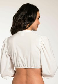White puff-sleeve crop top with textured fabric and elastic hem. Back view shows a simple neckline and smooth design.