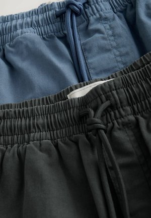 To sæt elastiske shorts med taljebånd, et i blå og et i mørkegrå. Begge har snører og en glat, blød tekstur.