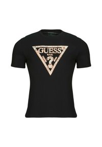 Camiseta negra de manga corta con un gran logo triangular de "GUESS" en un diseño contrastante, con textura suave y escote redondo.