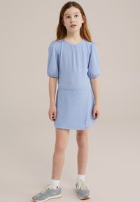 Light blue dress with textured fabric, short puff sleeves, and subtle embellishments. Paired with gray sneakers and white socks.