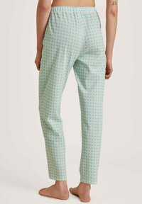 Lichte, gemusterde pyjamabroek in aqua met kleine oranje en crèmekleurige hexagons, met een elastische tailleband en een rechte pijpdesign.