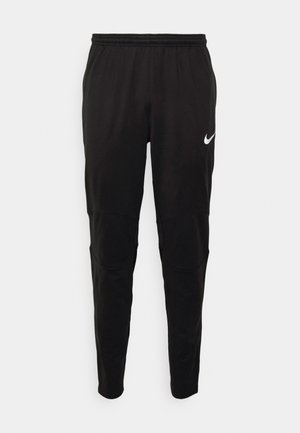 Pantalons de sport noirs fabriqués en tissu lisse avec une taille élastique. Présentent des renforcements aux genoux et un logo Nike blanc sur la gauche.