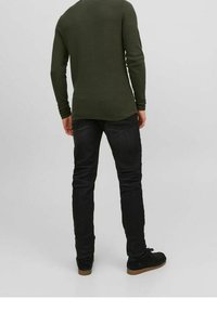 Zielony, długi sweter z dzianiny o teksturowanym wzorze, zestawiony z czarnymi, dopasowanymi dżinsami i ciemnymi butami. Standardowy widok od tyłu na neutralnym tle.