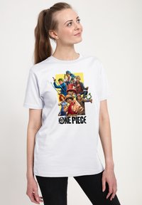 Camiseta de algodón blanca con un gráfico colorido de varios personajes de "One Piece" y texto negro debajo.
