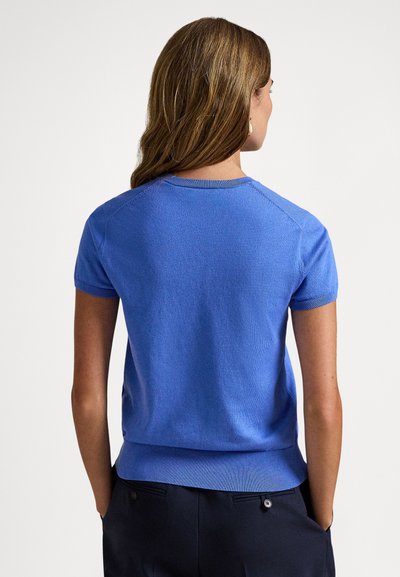 Πλεκτό μπλε πουλόβερ με κοντά μανίκια, στρογγυλή λαιμόκοψη, ριμπ μανσέτες και ελαφρύ τελείωμα. Ομαλή υφή και εφαρμοστή σιλουέτα.