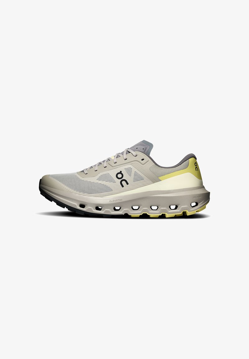 Chaussure de sport gris clair et jaune avec tige en mesh, semelle rembourrée avec plusieurs coussins d'air et logo noir sur le côté.