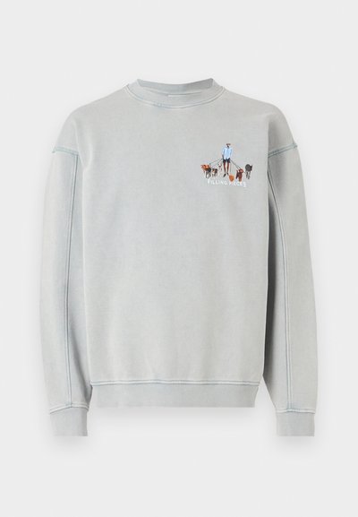 Világosszürke pulóver, bordázott nyakkal és mandzsettákkal, amelyen egy ember, aki több kutyát sétáltat, hímzett grafikája látható.
