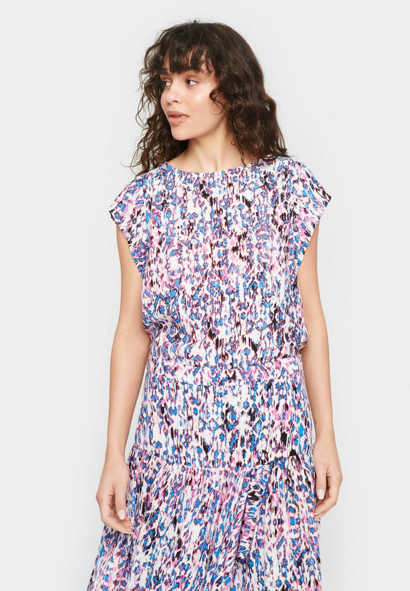 Blusa colorata e a fantasia con maniche a farfalla corte e scollo arricciato, in una fusione di tonalità rosa, blu e bianco.