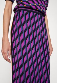 Gonna a maglia con motivo a zigzag diagonale in viola, blu e nero con accenti arancioni e vita aderente.