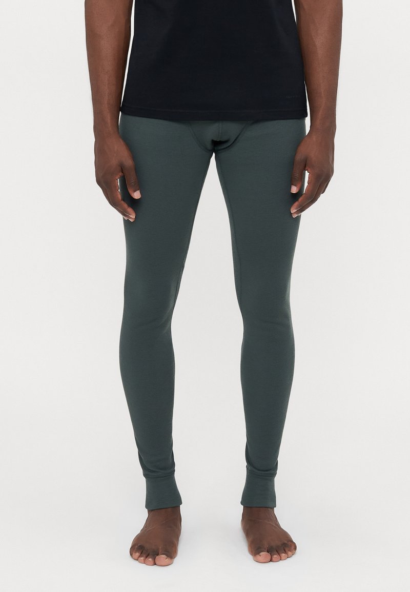 Mørkegrønne, letvægts leggings med en glat tekstur, tætsiddende design og ankellange manchetter, parret med en sort kortærmet skjorte.