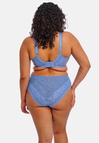 Vaaleansininen rintaliivi ja korkeavyötäröiset alushousut, joissa on pitsiä. Selässä on säädettävät hihnat ja koukku, joka takaa hyvän istuvuuden. Kuosisametti.