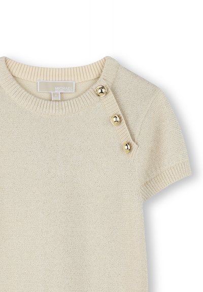 Pull en beige à manches courtes avec un col en côtes et trois boutons dorés le long de l'épaule gauche. Tissu en maille texturée.
