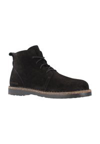 Stivaletti alla caviglia in suede nero con punta arrotondata, design con lacci e suola in sughero testurizzata. Presentano un sottile marchio sul lato.