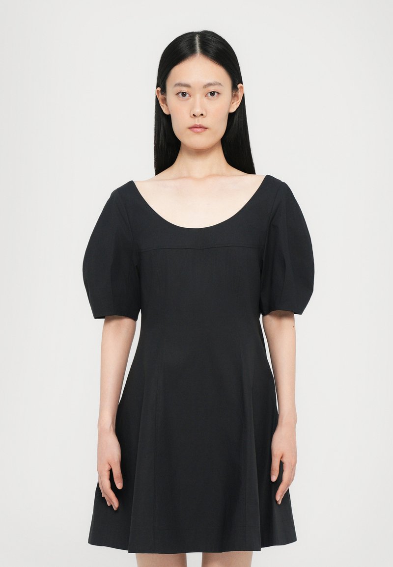 Black dress with a wide scoop neckline and puffed short sleeves. Fitted bodice leads to a flared skirt, made from smooth fabric.