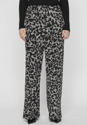 Bukser med vide ben i sort og grå leopardprint, kombineret med en sort ribstrikket sweater og sorte spidse sko.