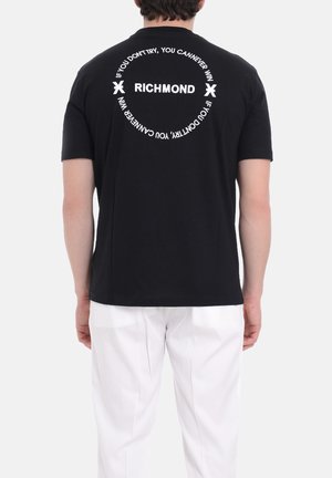 T-shirt in cotone nero con testo bianco sul retro: "RICHMOND" all'interno di un design circolare e uno slogan motivazionale. Maniche corte, vestibilità regolare.
