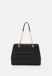 Black quilted handbag with a structured shape, featuring gold chain straps and embossed lettering. Smooth leather texture and subtle accents.