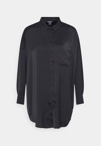 Camicia nera a maniche lunghe in tessuto morbido con chiusura a bottoni, colletto e una tasca sul petto. Presenta una vestibilità rilassata e un orlo curvo.