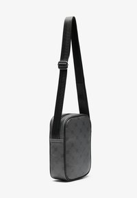 Black crossbody bag made of textured material, featuring a rectangular shape, adjustable strap, and subtle logo pattern on the exterior.