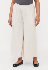 Beige wide-leg pants made of lightweight fabric with an elastic waistband. The texture is smooth, featuring a subtle heathered pattern.