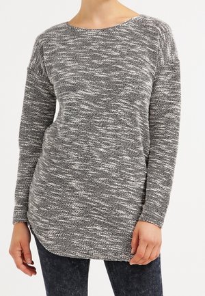 Maglione a maniche lunghe in un maglione intrecciato nero e bianco, con scollatura rotonda e orlo curvo per una silhouette rilassata.