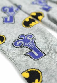 Calzini grigi con simboli di pipistrello in stile fumetto neri e gialli e decorazioni viola, con una morbida texture lavorata a maglia.