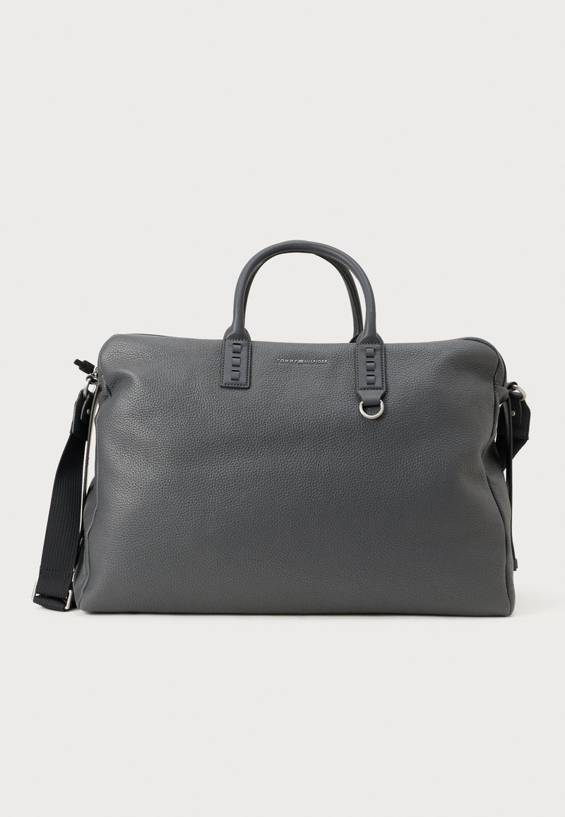 Sac en cuir texturé gris avec des poignées doubles, une bandoulière amovible et des accessoires en métal. Comprend une fermeture éclair et un détail de logo embossé.