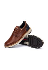 Scarpe in pelle marrone con una finitura liscia, caratterizzate da un accento in pelle blu scuro, suola beige e una suola in gomma testurizzata.