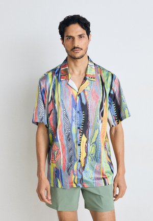 Chemise à manches courtes avec un motif abstrait coloré. Dotée d'un col, en tissu léger et d'une coupe décontractée.