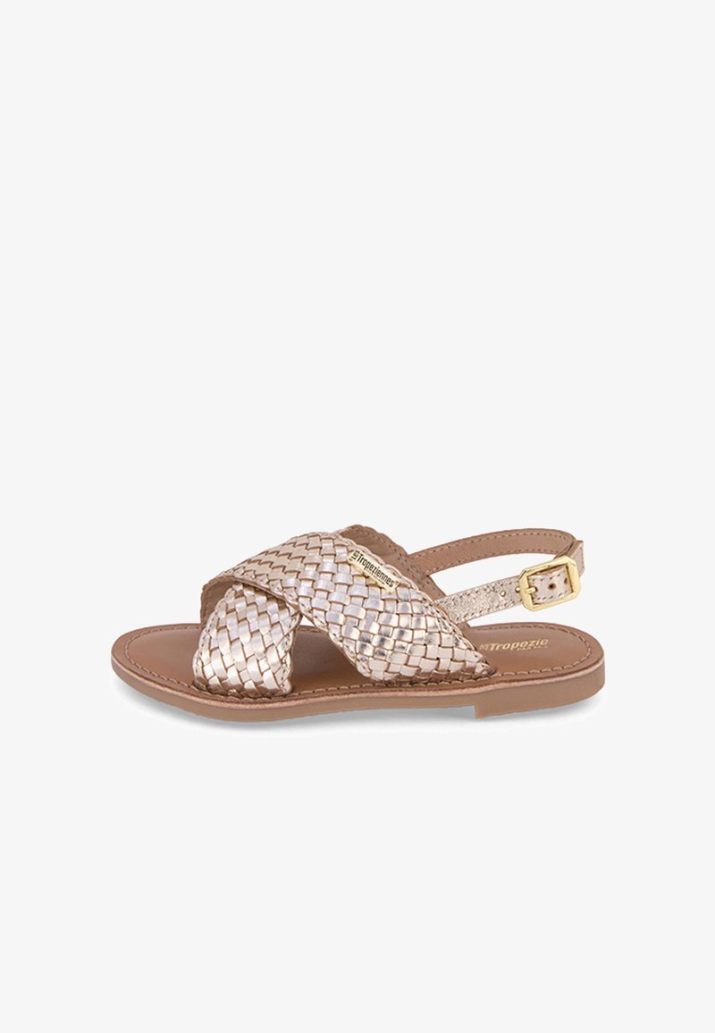 Sandales en cuir tressé doré métallisé avec des brides croisées, une bride réglable à la cheville et une semelle plate marron. Design léger.