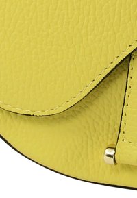 Gele leren handtas met een gestructureerd oppervlak, afgeronde klepsluiting, zwarte randafwerking en metalen sieraccenten.