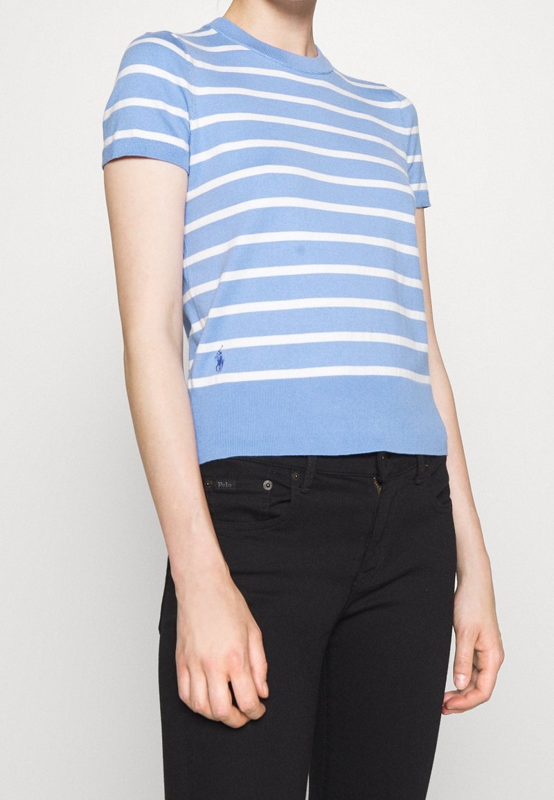 Ljust blå kortärmad randig T-shirt med vita horisontella ränder, ribbad halsringning och en liten broderad logotyp på vänster sida.