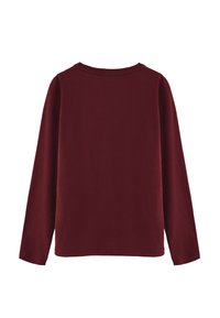 Camisa de manga larga en burdeos, hecha de una tela suave, con un escote redondo y un corte relajado. Diseño sencillo sin patrones ni acentos adicionales.