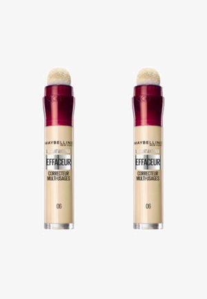 Des tubes de correcteur Maybelline en beige avec des embouts applicateurs en éponge et des bouchons rouges. Comprend un texte multilingue et des détails sur le produit sur le corps.