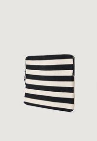 Μαύρη και λευκή ριγέ θήκη για λάπτοπ φτιαγμένη από υφασμάτινη υφή, με ασφάλιση με φερμουάρ κατά μήκος της επάνω άκρης και κομψό ορθογώνιο σχήμα.