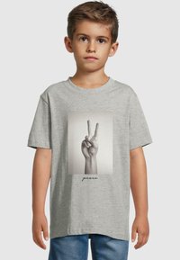 Gray cotton t-shirt featuring a black and white print of a hand making a peace sign, with the word "peace" printed below in cursive.