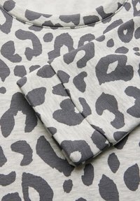 Sweat-shirt à imprimé léopard avec un tissu doux et texturé en tons de gris, dotée d'un col rond et de manches retroussées.