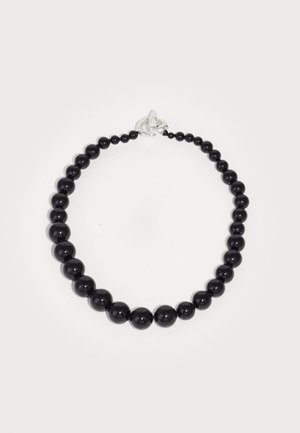 Collier noir en perles comportant des perles sphériques brillantes de différentes tailles, fermées par un clip argenté.