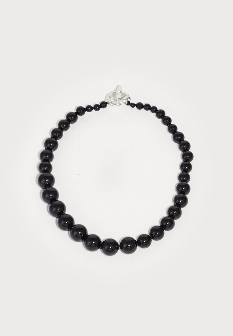 Μαύρο κολιέ από χάντρες, κατασκευασμένο από γυαλιστερές σφαιρικές χάντρες διαφόρων μεγεθών, κλεισμένο με κούμπωμα ασημί.