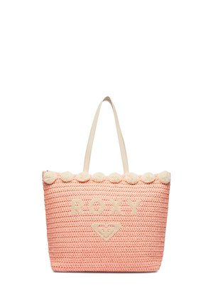Pink vævet tote taske med cremefarvede pomponer langs øverste kant, cremefarvede håndtag og "ROXY" tekst med hjerte-logo på fronten.