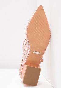 Chaussure tissée rose à bout pointu avec un petit talon carré. La semelle est lisse, avec une texture et une étiquette de taille indiquant "37".