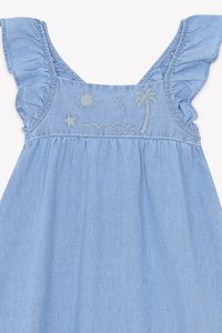 Lys blå denimkjole med volangstropper, med broderte motiver av sol, palmetre, bølger og stjerner på kroppen.