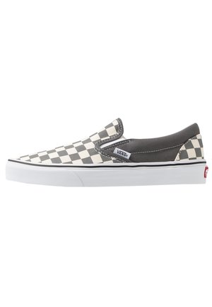 Baskets basses Vans slip-on avec motif damier noir et blanc à l'avant, talon uni gris foncé et semelle en caoutchouc blanche.