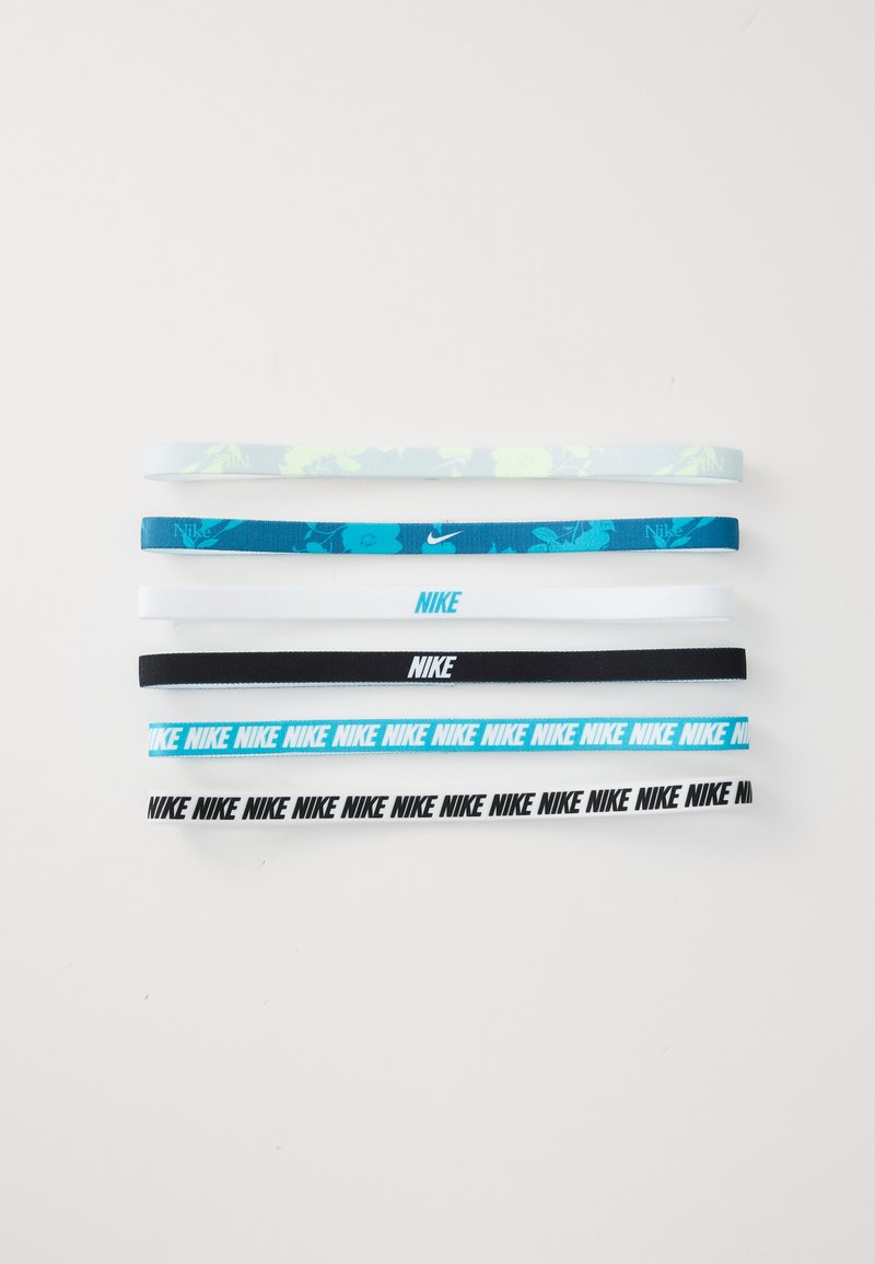 Συσκευασία με έξι κοτσιδάκια σε διάφορα πλάτη. Τα χρώματα περιλαμβάνουν ανοιχτό μπλε, τιρκουάζ, λευκό και μαύρο. Διαθέτουν επαναλαμβανόμενο λογότυπο "Nike" και φλοράλ μοτίβα.