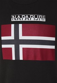 Camiseta negra con un gran gráfico de la bandera noruega en rojo y blanco con una cruz azul, y el texto "NAPAPIJRI" arriba en blanco.