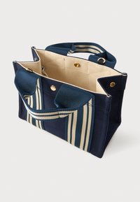 Ναυτικό μπλε τσάντα καμβά με κρεμ εσωτερικό και φαρδιές χειρολαβές με μπλε και κρεμ ρίγες, ανοιχτή κορυφή με χρυσά κουμπιά.