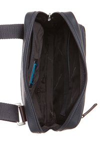 Borsa nera in pelle con texture e cerniera aperta. L'interno presenta una fodera nera liscia e una tasca con zip. Cinghia regolabile attaccata.